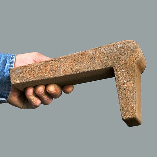  A pool Edge Coping held a man's hand, extended from blue work shirt. Photo background is a light blueish gray