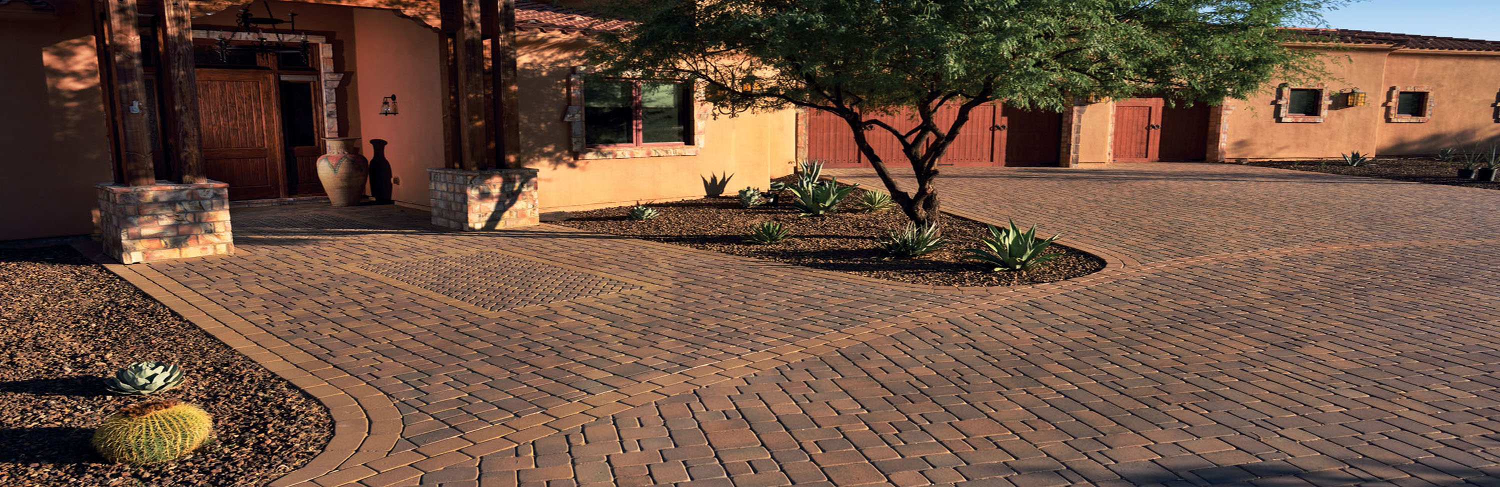 Photograph of Phoenix Paver's Standard Pavers installed in mixed patterns in entry way and circular drive in front of southwestern adobe plastered home with three car garage