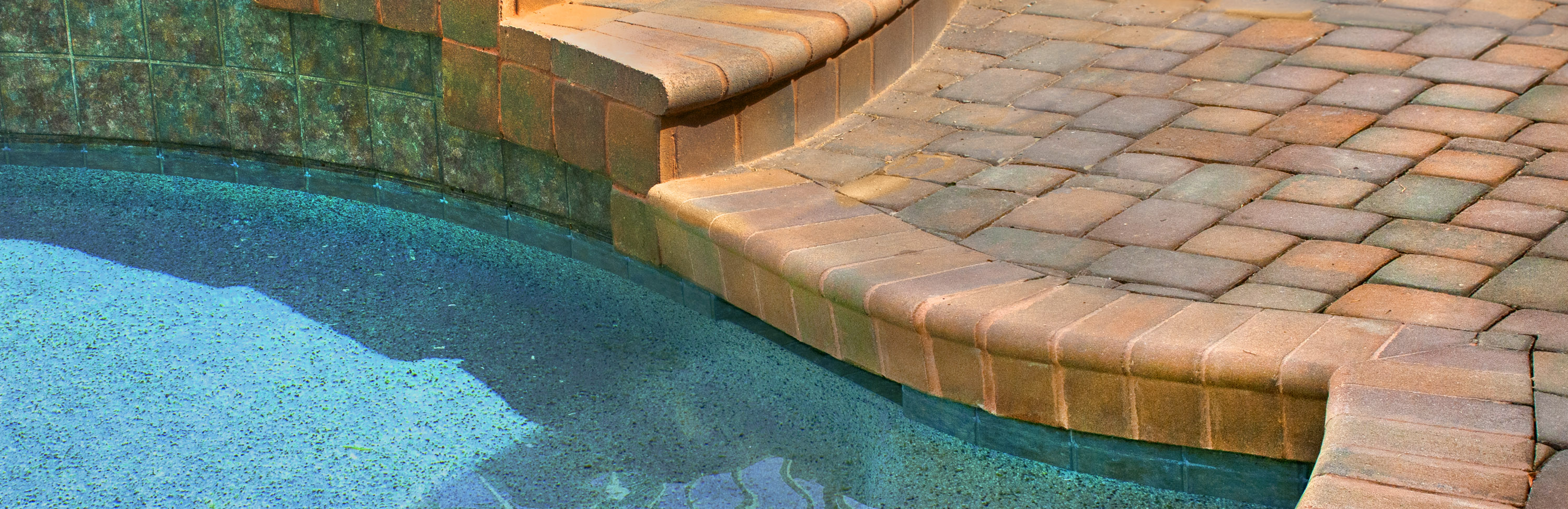 Photograph of Phoenix Paver's Veneer Pavers installed as a multi level pool surround Pool Coping pavers used as steps and pool edge..